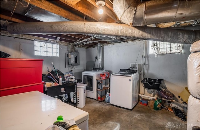 basement featuring electric panel and washing machine and clothes dryer