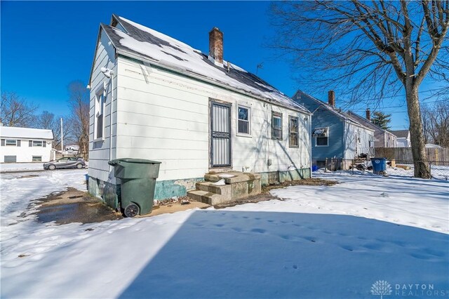 view of snow covered rear of property