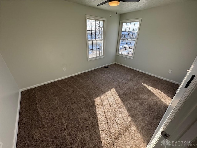 spare room with visible vents, baseboards, ceiling fan, carpet, and a textured ceiling