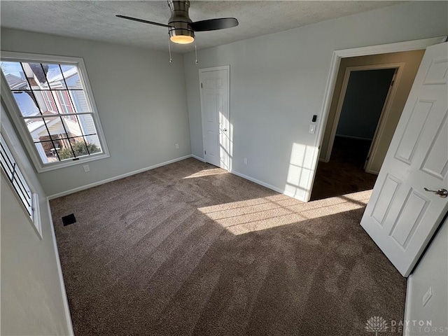 spare room featuring a ceiling fan, carpet flooring, a textured ceiling, and baseboards