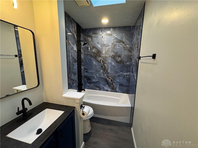 bathroom with shower / washtub combination, toilet, a textured ceiling, vanity, and wood finished floors