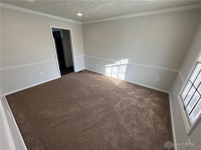 carpeted empty room with a textured ceiling and ornamental molding