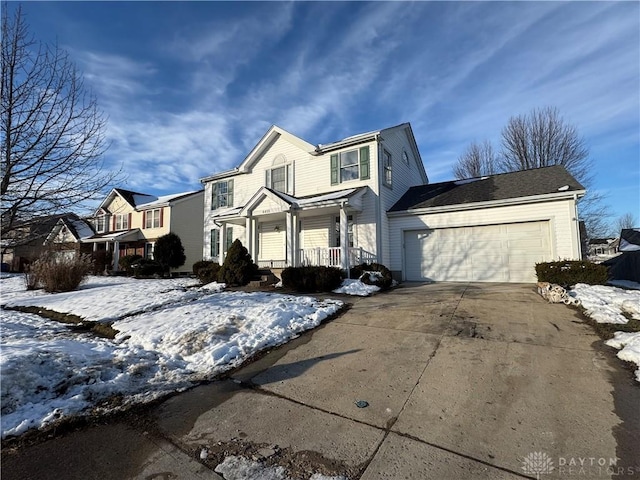 traditional home with covered porch, concrete driveway, and a garage