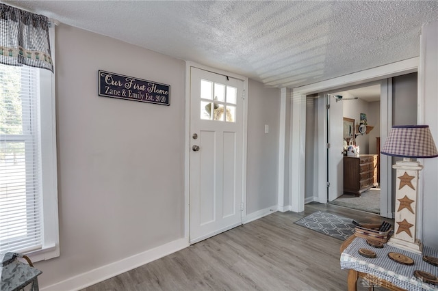 entryway with light hardwood / wood-style flooring and a textured ceiling