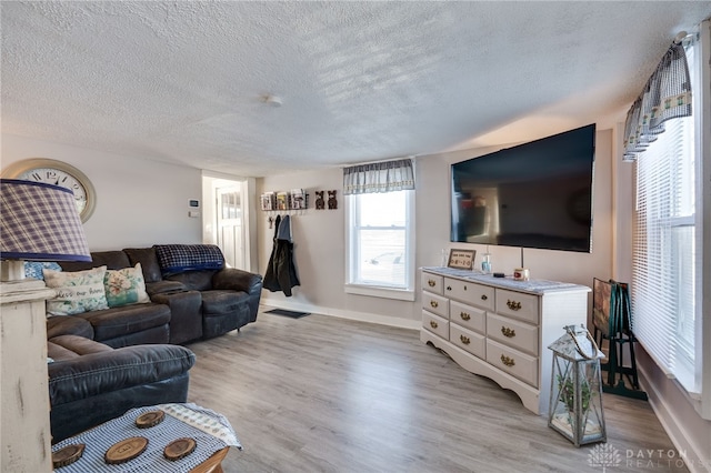 living room with light hardwood / wood-style floors and a textured ceiling