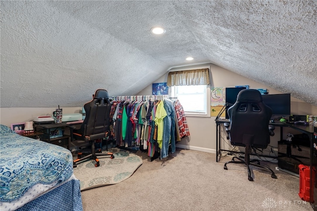 bedroom with vaulted ceiling, carpet floors, and a textured ceiling