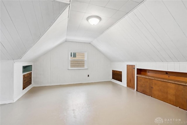 additional living space with vaulted ceiling and wooden walls