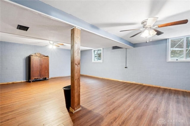 basement featuring light hardwood / wood-style floors and brick wall