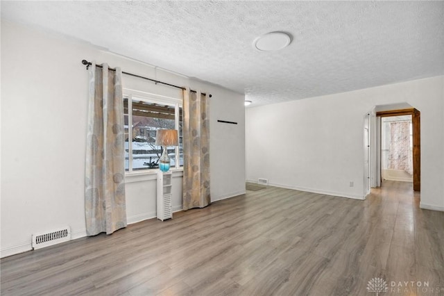 empty room featuring light hardwood / wood-style floors and a textured ceiling