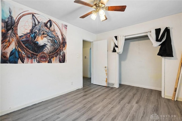 unfurnished bedroom with ceiling fan and hardwood / wood-style flooring