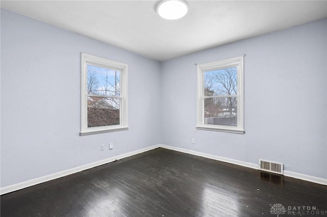 unfurnished room with dark wood-type flooring and a healthy amount of sunlight