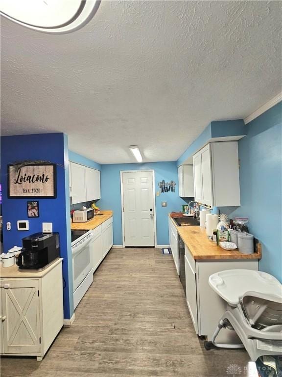 kitchen with wood counters, white appliances, white cabinets, light hardwood / wood-style flooring, and sink