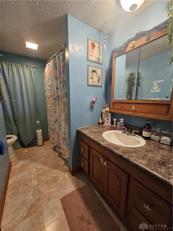 bathroom featuring a textured ceiling, tile patterned flooring, and vanity