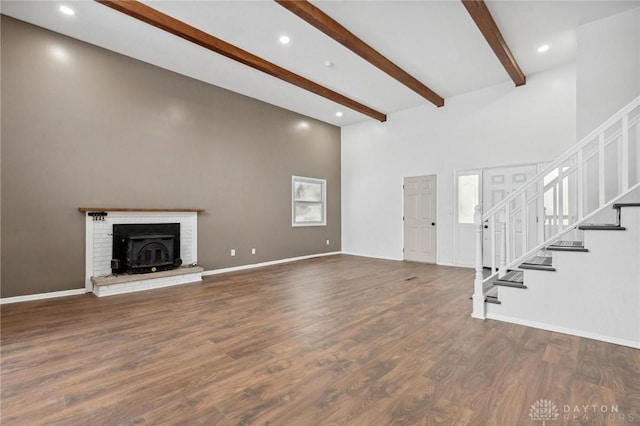 unfurnished living room featuring hardwood / wood-style floors and beamed ceiling