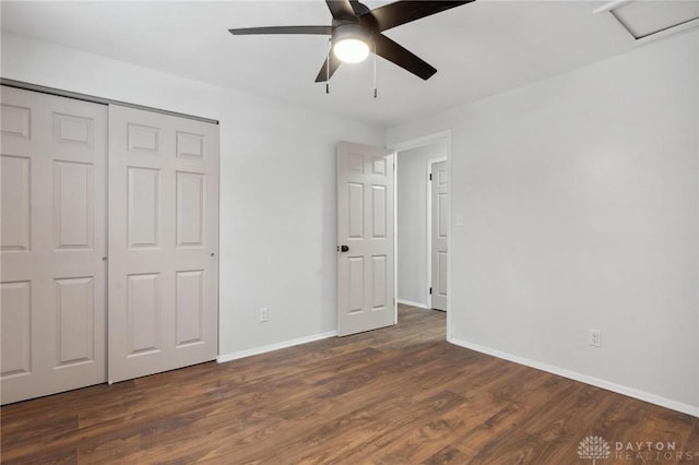 unfurnished bedroom featuring ceiling fan, a closet, and dark wood-type flooring