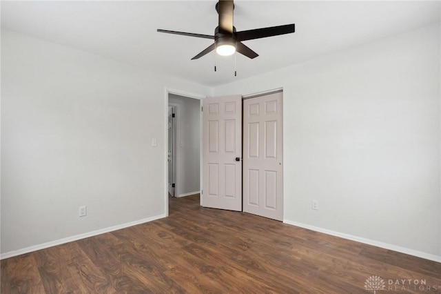 unfurnished bedroom with dark wood-type flooring, ceiling fan, and a closet