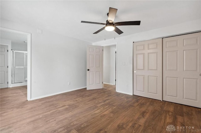 unfurnished bedroom featuring ceiling fan, a closet, dark hardwood / wood-style flooring, and ensuite bathroom