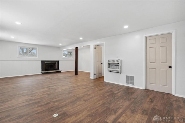 unfurnished living room with dark wood-type flooring and heating unit