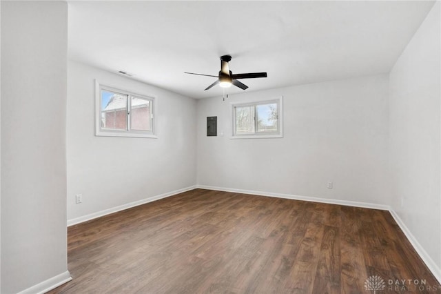 empty room featuring ceiling fan, dark wood-type flooring, and electric panel