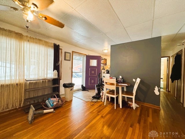 dining space featuring a paneled ceiling, hardwood / wood-style flooring, and ceiling fan