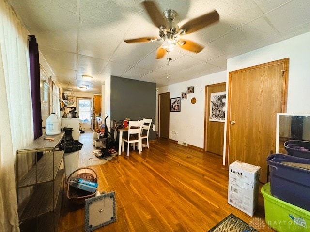 interior space featuring ceiling fan, a paneled ceiling, and hardwood / wood-style flooring