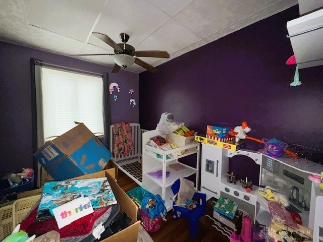 playroom with ceiling fan and a paneled ceiling