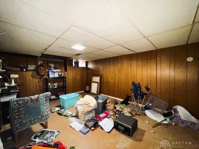 interior space featuring a paneled ceiling and wood walls