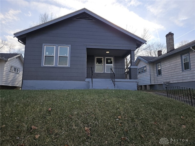 rear view of property with a porch and a yard