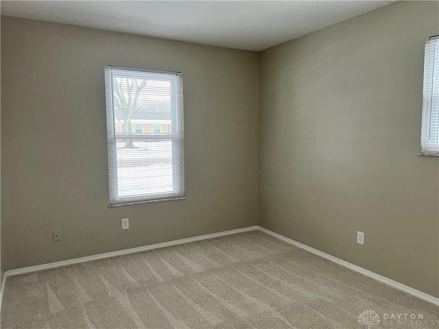 spare room featuring light carpet