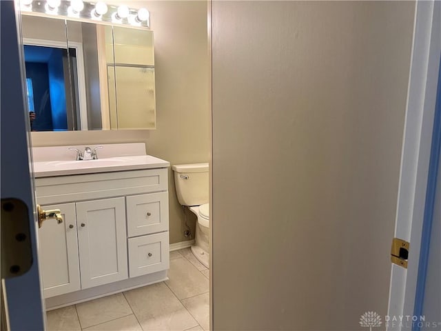 bathroom featuring toilet, vanity, and tile patterned flooring