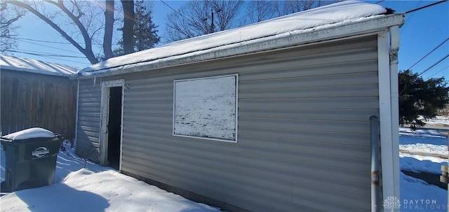 view of snowy exterior featuring an outbuilding