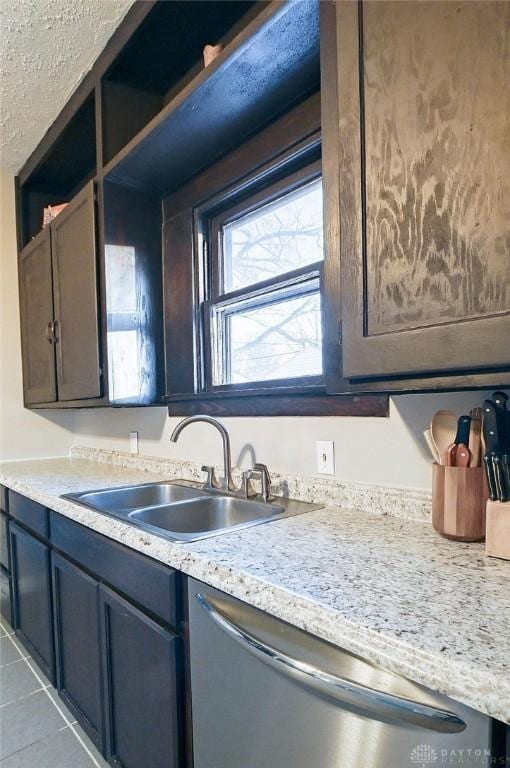 kitchen featuring tile patterned flooring, light countertops, a sink, and stainless steel dishwasher