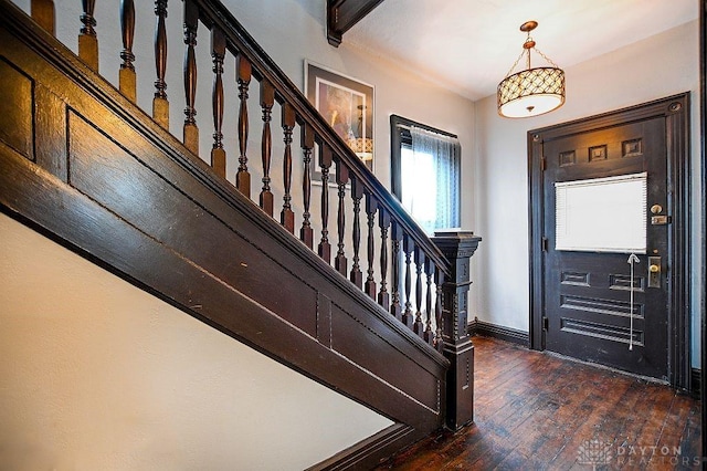 entryway featuring hardwood / wood-style flooring, stairs, and baseboards