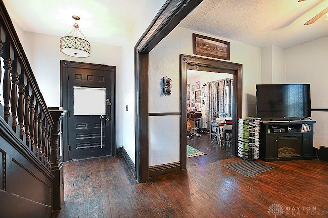 foyer entrance with wood-type flooring, stairs, and baseboards