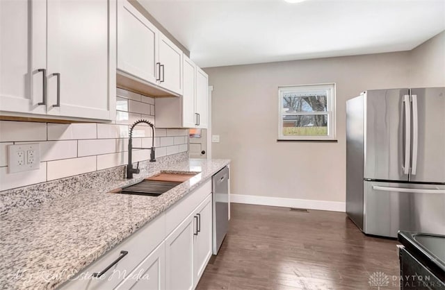 kitchen featuring light stone countertops, sink, white cabinetry, and appliances with stainless steel finishes