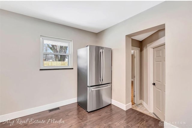 kitchen with dark wood-type flooring and stainless steel refrigerator