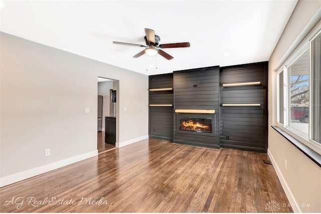 unfurnished living room with ceiling fan, a fireplace, and hardwood / wood-style floors