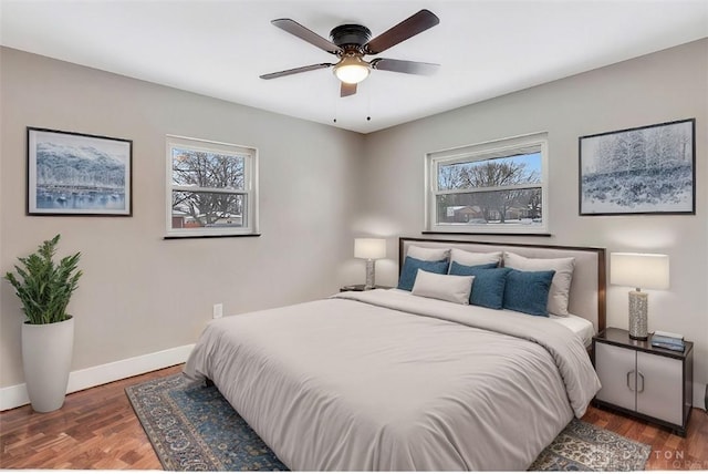 bedroom with ceiling fan, multiple windows, and dark hardwood / wood-style floors