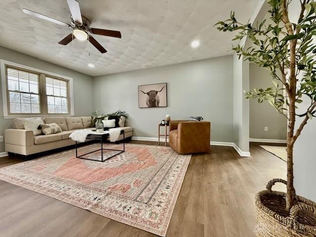 living room featuring ceiling fan and wood-type flooring