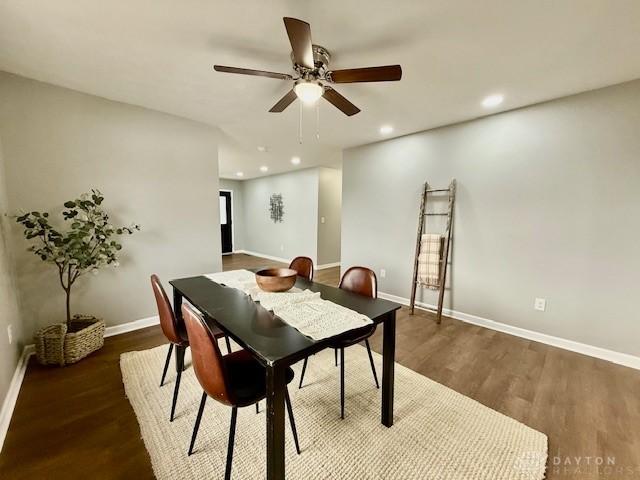 dining space with ceiling fan and dark wood-type flooring