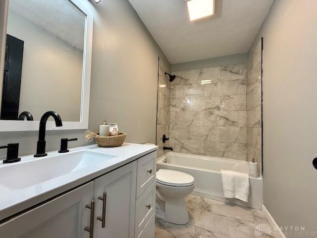 full bathroom featuring toilet, tiled shower / bath combo, and vanity