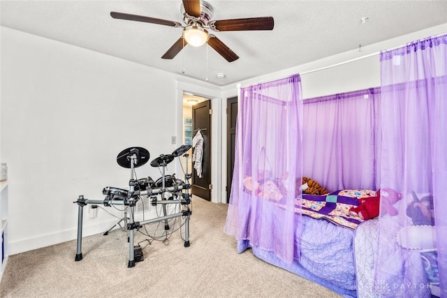 exercise area with carpet floors, a textured ceiling, and ceiling fan