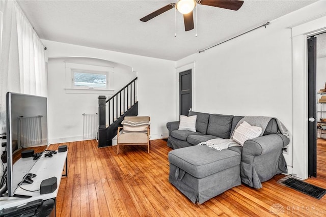 living room featuring ceiling fan, a textured ceiling, light hardwood / wood-style flooring, and radiator