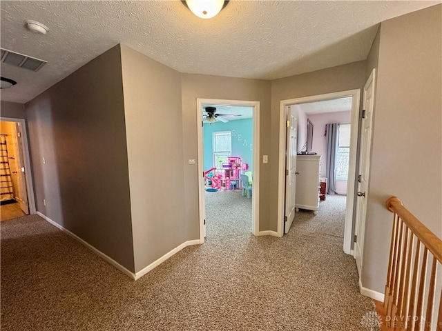 corridor featuring carpet and a textured ceiling