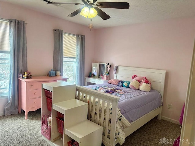 carpeted bedroom with ceiling fan and multiple windows