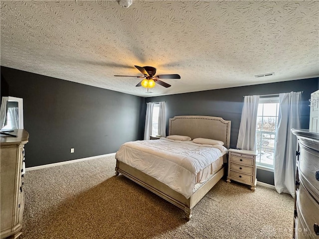 carpeted bedroom featuring a textured ceiling, ceiling fan, and multiple windows