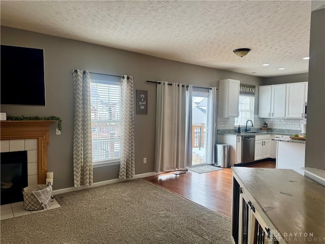 kitchen with sink, white cabinetry, dishwasher, and a textured ceiling