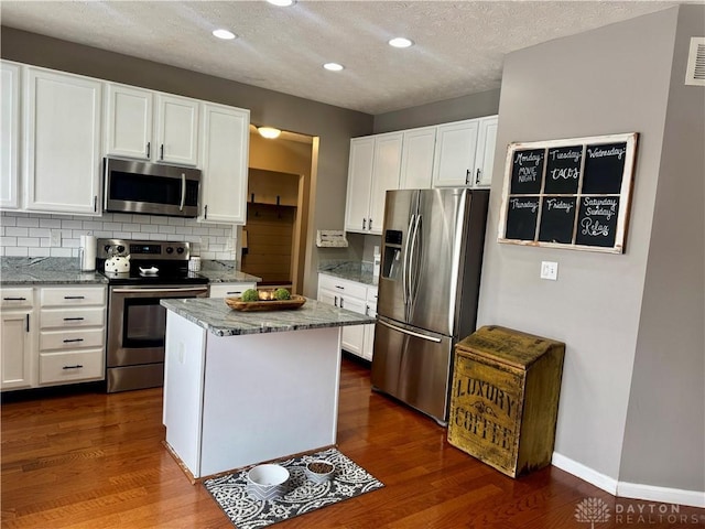 kitchen featuring appliances with stainless steel finishes, white cabinets, and a kitchen island