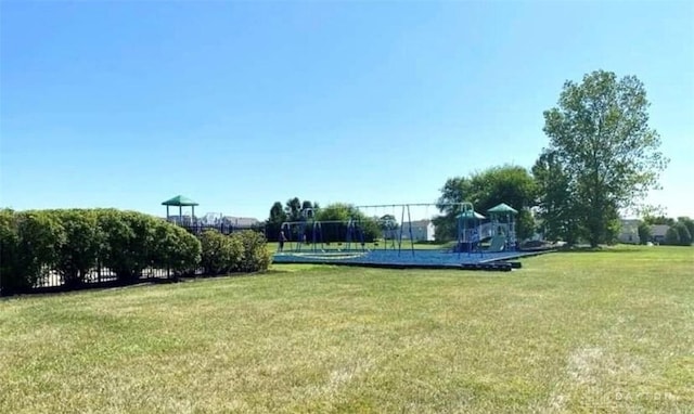 view of property's community with a playground and a yard