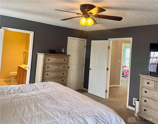 bedroom with ensuite bathroom, ceiling fan, carpet floors, and a textured ceiling